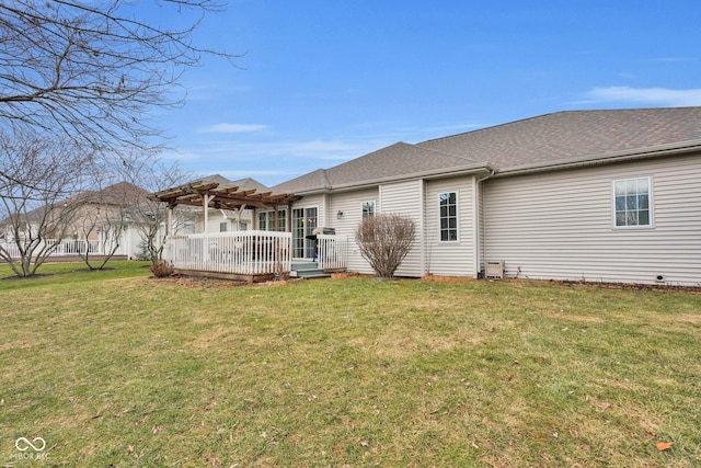 back of house with a wooden deck, a pergola, and a lawn