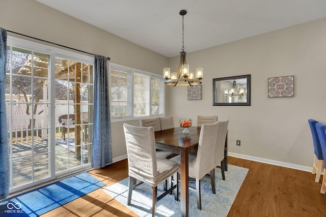 dining space featuring hardwood / wood-style flooring and a notable chandelier