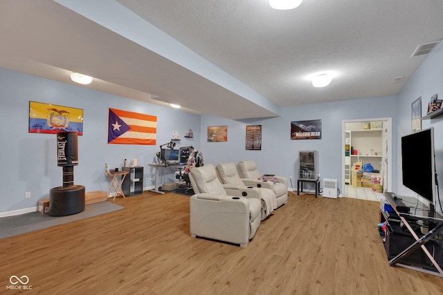 living room with a textured ceiling and light hardwood / wood-style flooring