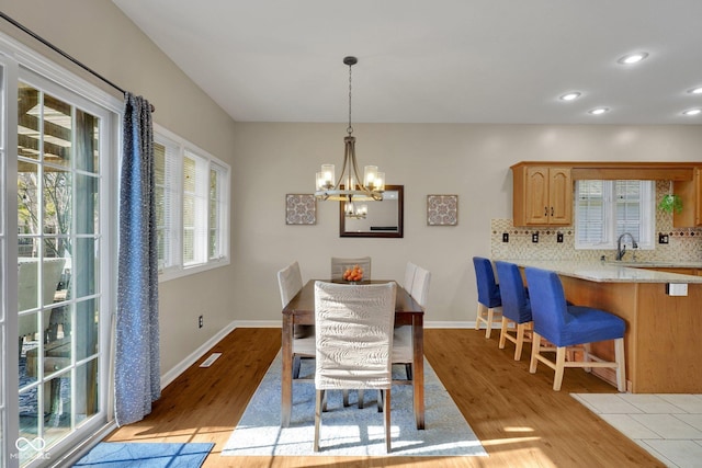 dining space featuring plenty of natural light, a chandelier, and light wood-type flooring