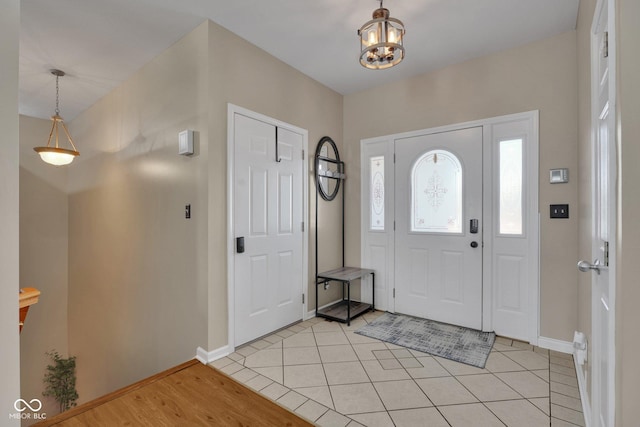 entrance foyer with light tile patterned floors and an inviting chandelier