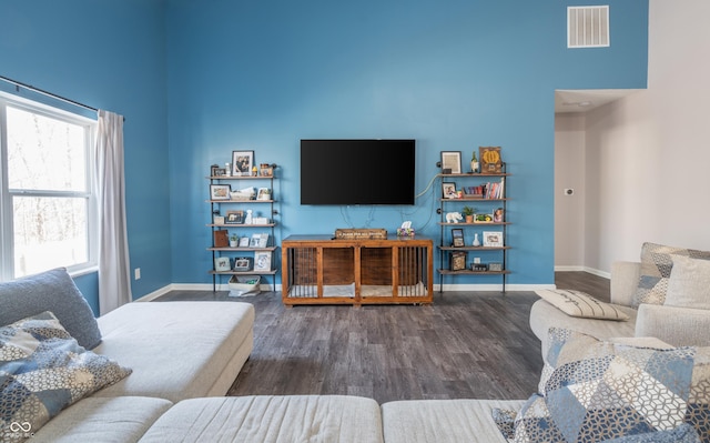 living room with dark wood-type flooring and a high ceiling