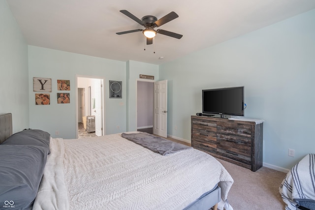 bedroom with connected bathroom, light carpet, and ceiling fan