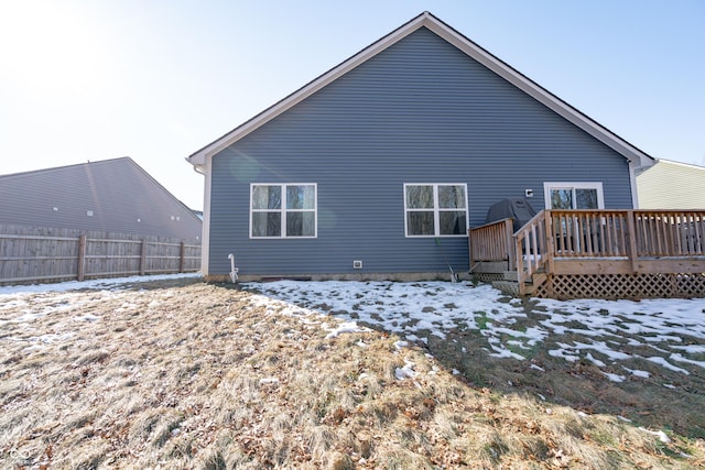 snow covered back of property featuring a wooden deck