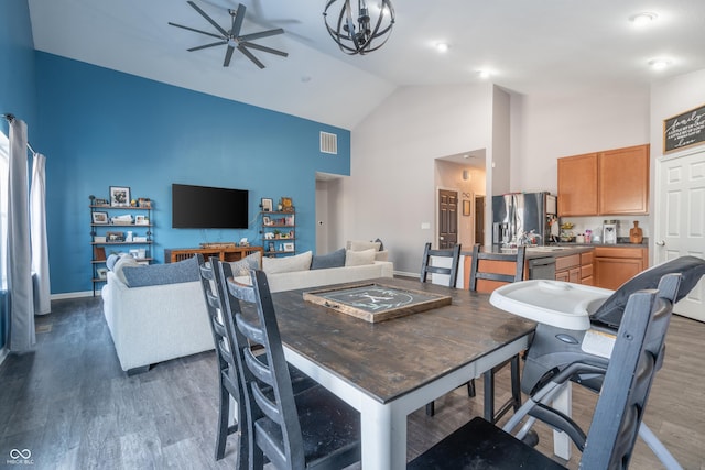 dining room featuring dark hardwood / wood-style flooring, high vaulted ceiling, and ceiling fan