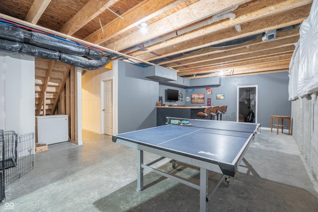 rec room featuring concrete floors and bar area