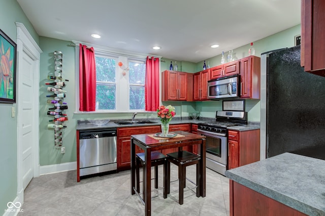 kitchen with stainless steel appliances, sink, and light tile patterned floors