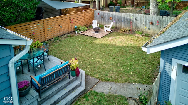 view of yard with a wooden deck and a fire pit