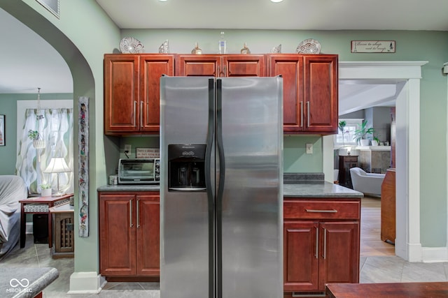 kitchen featuring stainless steel refrigerator with ice dispenser and light tile patterned floors