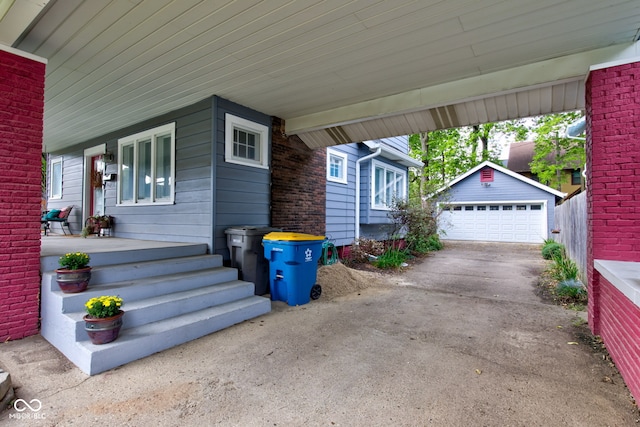 view of side of home featuring a garage, an outdoor structure, and covered porch