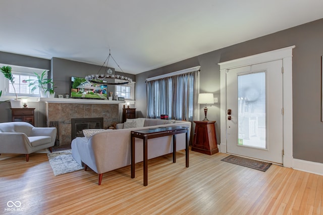 living room featuring a tiled fireplace and light hardwood / wood-style floors