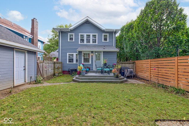 rear view of house featuring a deck and a lawn