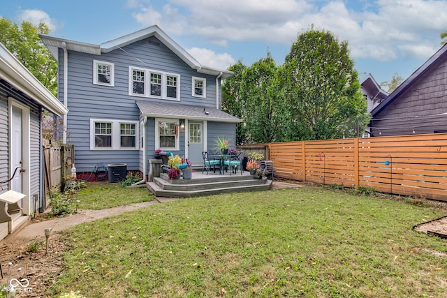 rear view of property featuring a wooden deck and a lawn