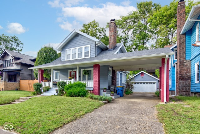 view of front facade featuring an outbuilding, a garage, a front yard, and covered porch