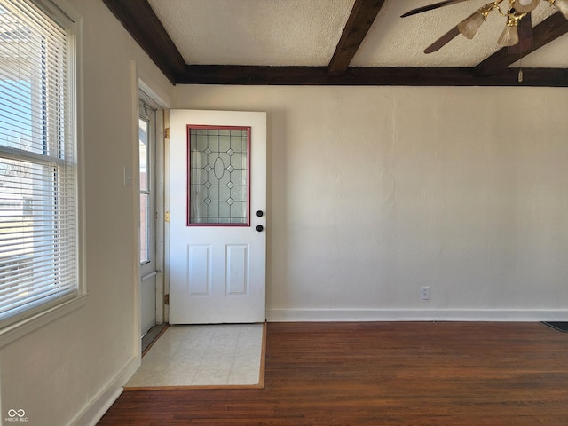 entrance foyer featuring beam ceiling, wood finished floors, baseboards, and a healthy amount of sunlight