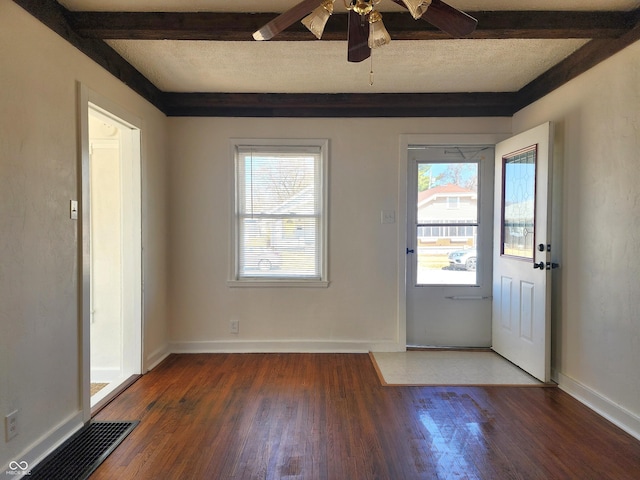 foyer entrance with visible vents, baseboards, beam ceiling, a textured ceiling, and wood-type flooring