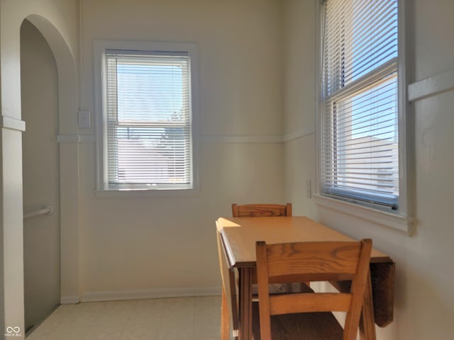 dining area featuring baseboards and arched walkways