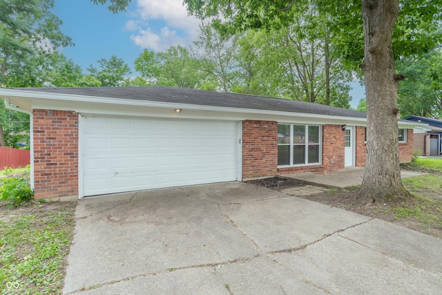 ranch-style home with brick siding, concrete driveway, and an attached garage