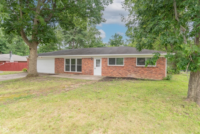 ranch-style house with driveway, fence, a front yard, a garage, and brick siding