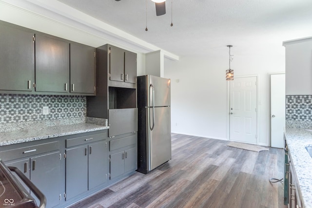 kitchen featuring wood finished floors, freestanding refrigerator, gray cabinetry, ceiling fan, and backsplash