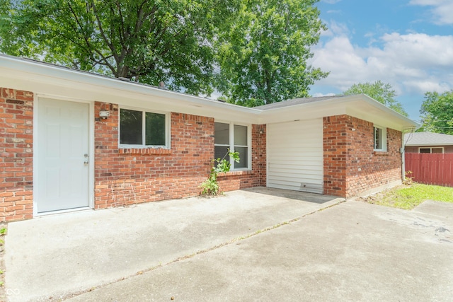 view of front of house featuring brick siding and fence