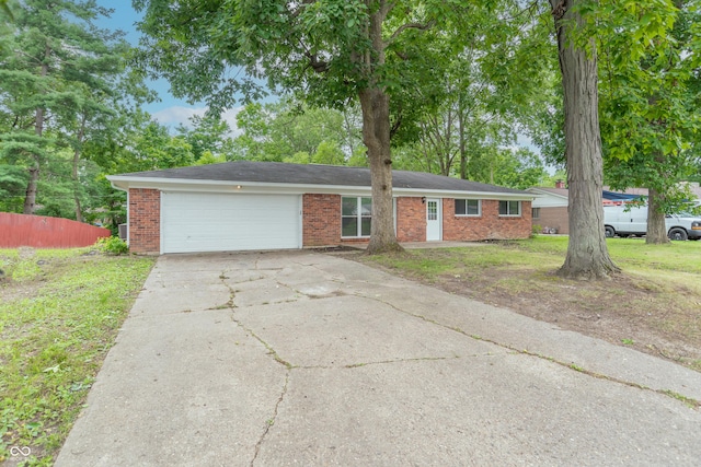 ranch-style house with concrete driveway, a garage, fence, and brick siding