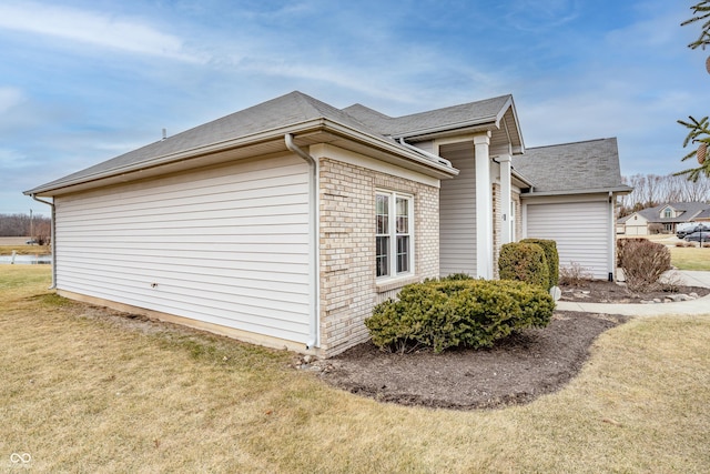 view of home's exterior featuring a yard and brick siding