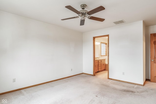 unfurnished bedroom featuring ensuite bathroom, light carpet, a ceiling fan, visible vents, and baseboards