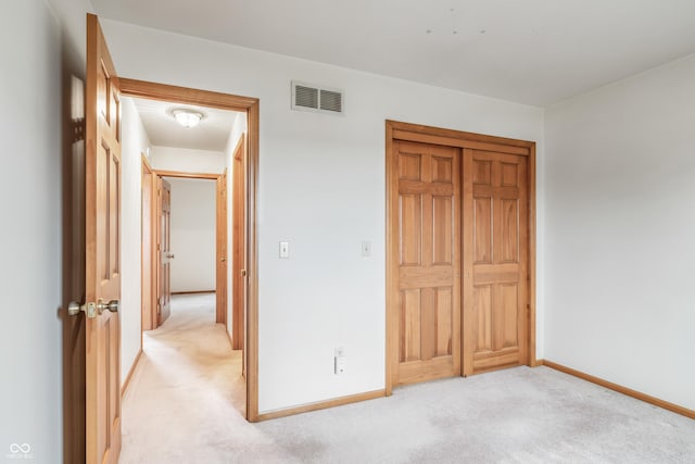 unfurnished bedroom featuring light carpet, baseboards, and visible vents