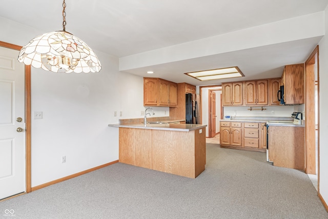 kitchen featuring black appliances, a peninsula, light countertops, and baseboards