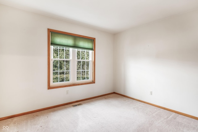 carpeted spare room featuring visible vents and baseboards