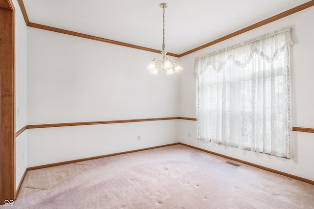 spare room with ornamental molding, carpet, visible vents, and an inviting chandelier