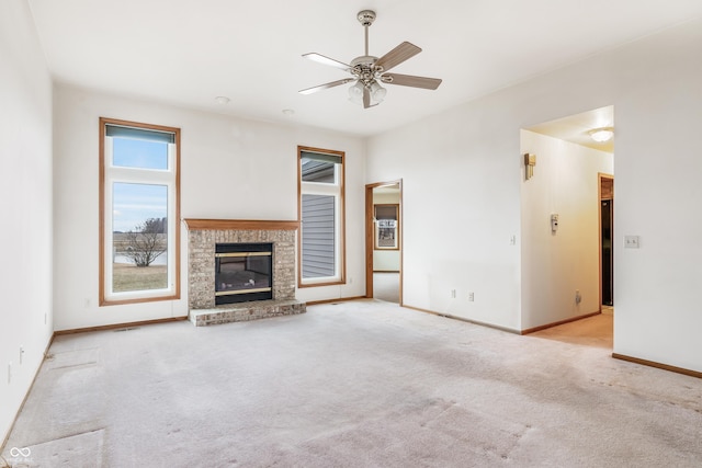 unfurnished living room featuring carpet, a fireplace, baseboards, and ceiling fan