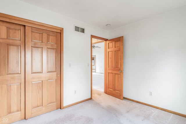 unfurnished bedroom with light carpet, visible vents, and baseboards