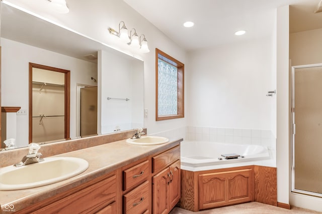 full bath featuring a garden tub, a sink, a shower stall, and double vanity