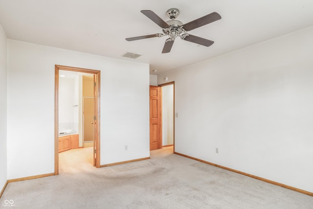 unfurnished bedroom featuring light carpet, visible vents, baseboards, ensuite bath, and ceiling fan