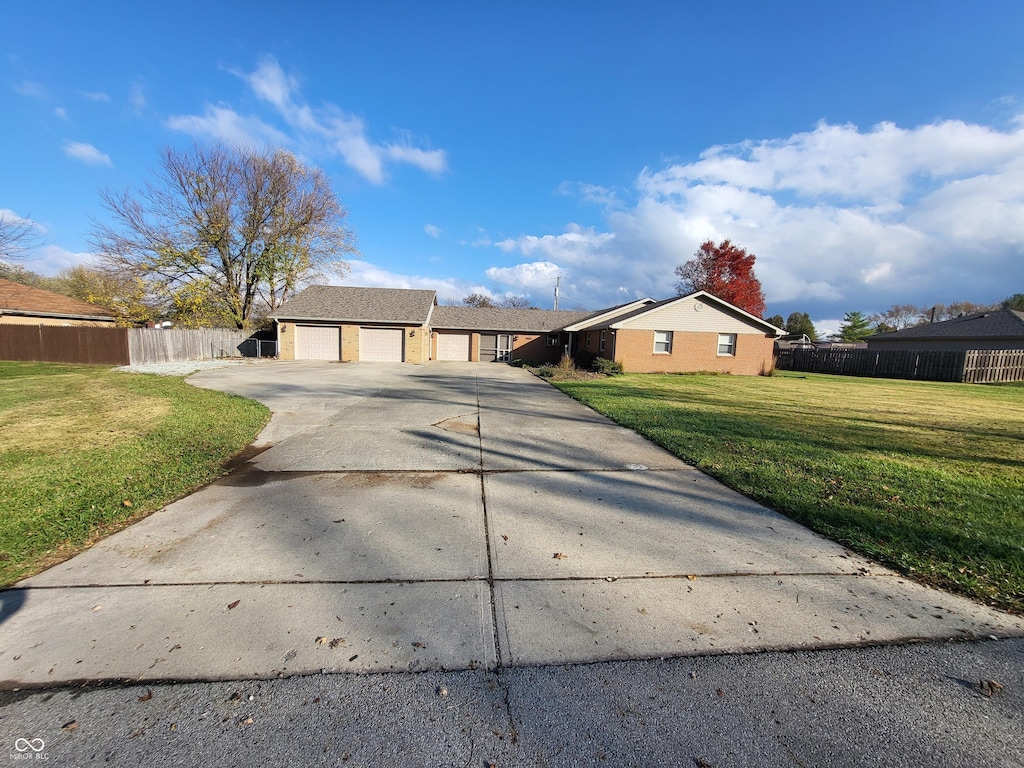 single story home with a garage and a front lawn