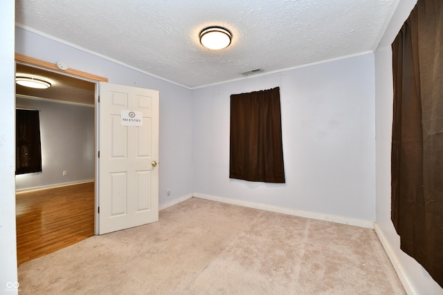 unfurnished room featuring light carpet and a textured ceiling