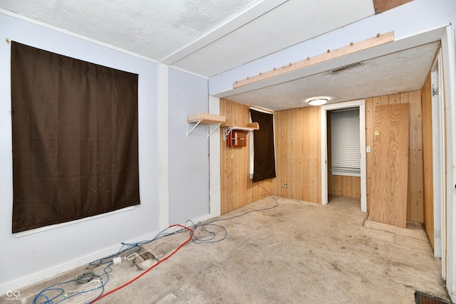 spare room with wooden walls and a textured ceiling