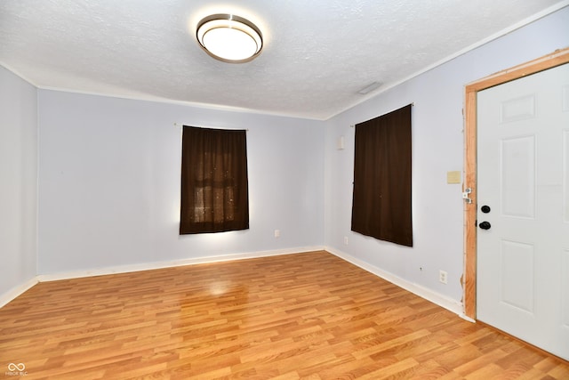 unfurnished room with a textured ceiling and light wood-type flooring