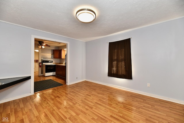 spare room featuring a textured ceiling and light hardwood / wood-style floors