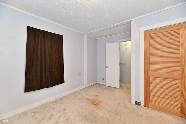 unfurnished bedroom with light colored carpet, a closet, and a textured ceiling