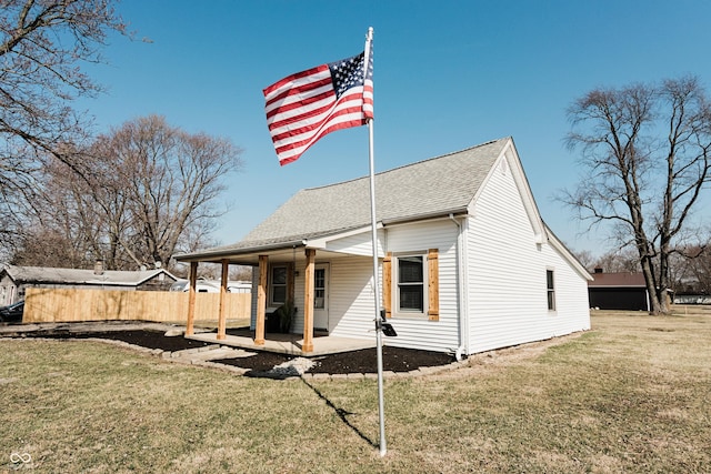 back of house featuring a patio, a lawn, roof with shingles, and fence