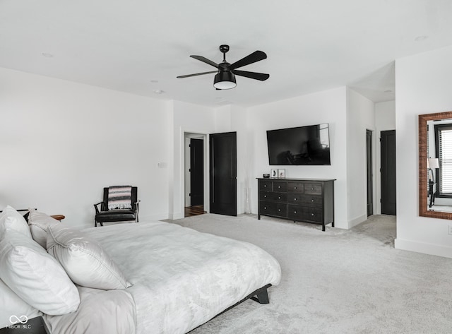 bedroom with a ceiling fan, light colored carpet, and baseboards