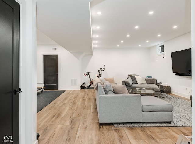 living room featuring baseboards, light wood-style flooring, visible vents, and recessed lighting