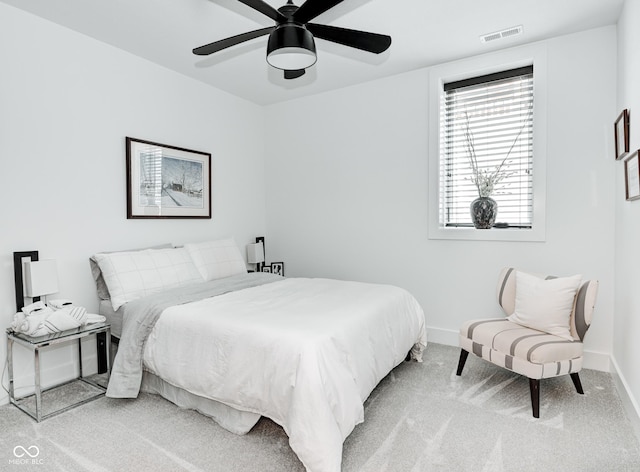 carpeted bedroom featuring baseboards, visible vents, and a ceiling fan