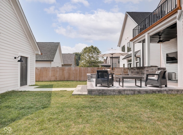 view of yard with a patio area, ceiling fan, an outdoor living space, and fence