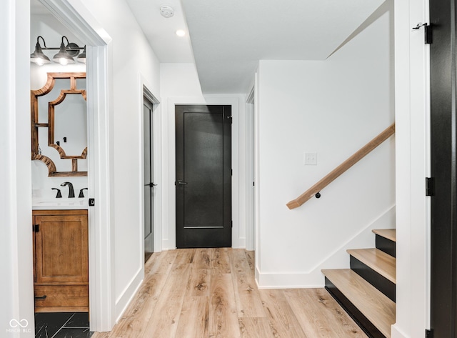 foyer entrance with light wood-type flooring and stairway