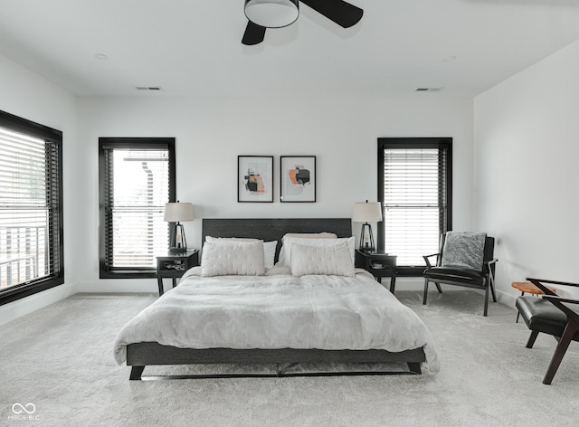 bedroom featuring light colored carpet, ceiling fan, visible vents, and baseboards