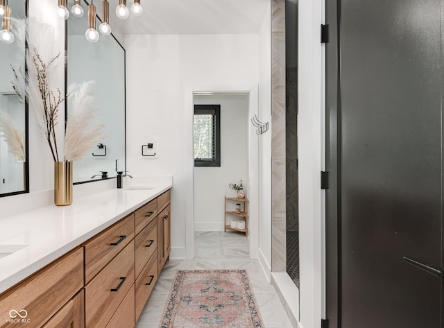 full bath with double vanity, baseboards, a shower, and a sink